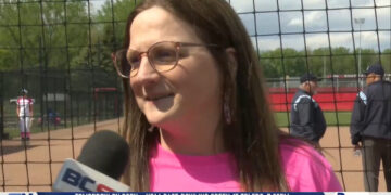 Christine Kwaitkowski Throws First Pitch In Bedford’s Breast Cancer Awareness 15-0 Shutout Win